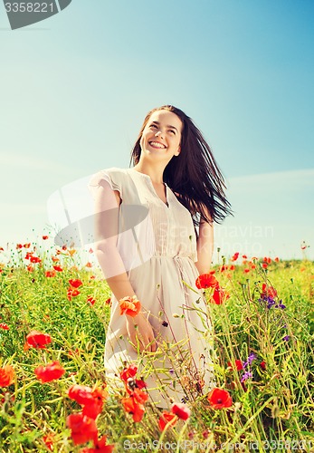 Image of smiling young woman on poppy field