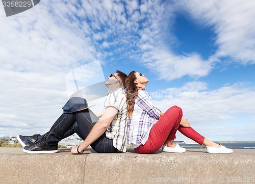 Image of teenagers sitting back to back