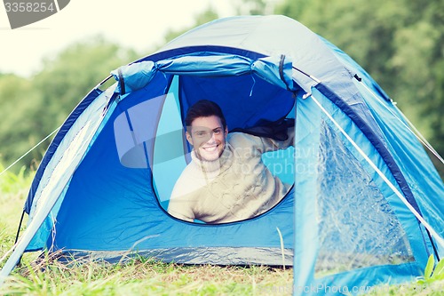 Image of smiling male tourist in tent