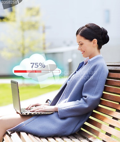 Image of smiling business woman with laptop in city