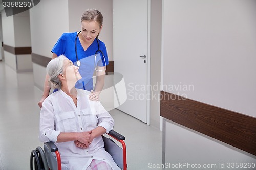 Image of nurse with senior woman in wheelchair at hospital