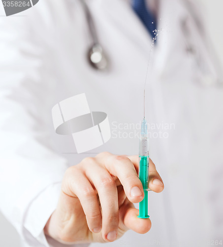 Image of male hand holding syringe with injection