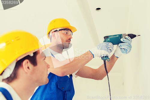 Image of group of builders with drill indoors