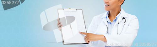 Image of close up of smiling female doctor with clipboard