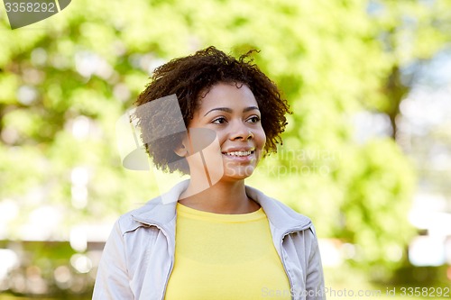 Image of happy african american young woman in summer park