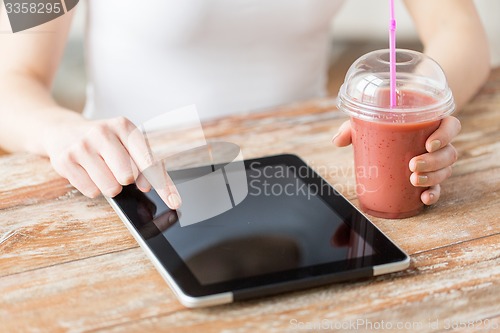 Image of close up of woman with tablet pc and smoothie