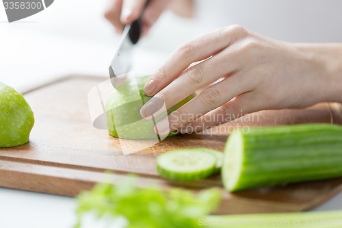 Image of close up of woman hands chopping green vegetables