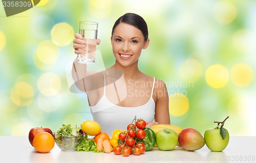 Image of happy woman with healthy food showing water glass