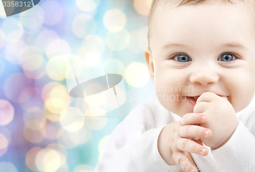 Image of happy baby over blue holidays lights background