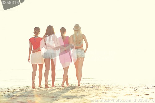 Image of group of young women walking on beach