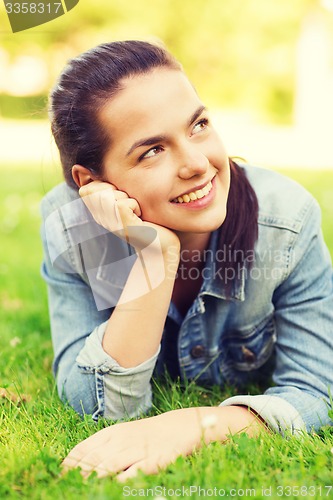 Image of smiling young girl lying on grass