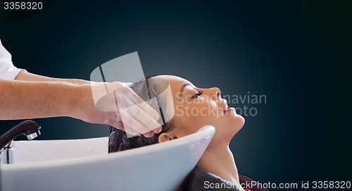 Image of happy young woman at hair salon