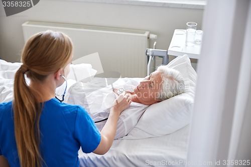 Image of nurse with stethoscope and senior woman at clinic