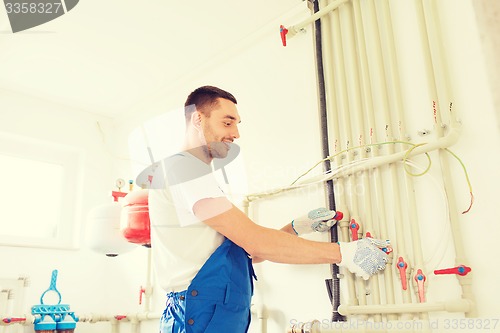 Image of smiling builder or plumber working indoors