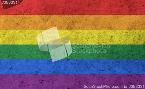 Image of gay rainbow flag on concrete wall surface