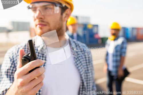 Image of close up of builder in hardhat with walkie talkie