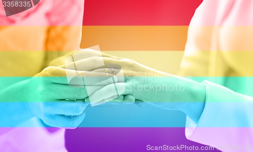 Image of close up of lesbian couple hands with wedding ring