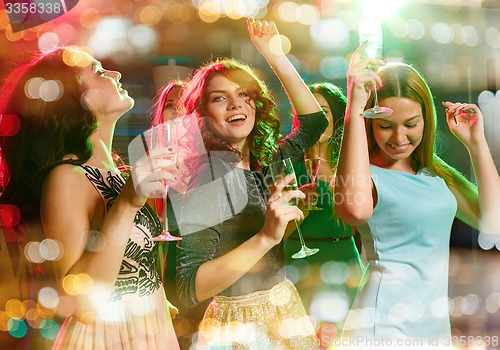 Image of smiling friends with glasses of champagne in club