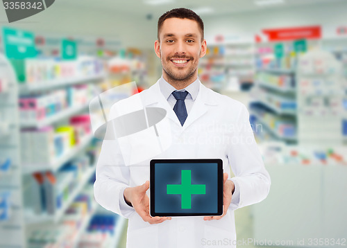 Image of smiling male doctor with tablet pc at drugstore