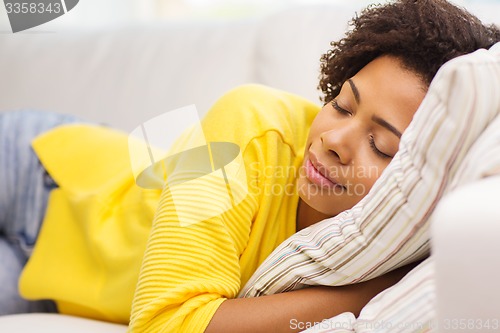 Image of african young woman sleeping on sofa at home