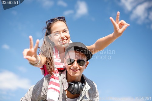 Image of smiling teenagers in sunglasses having fun outside