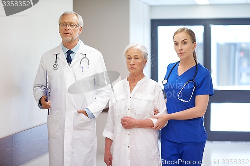 Image of medics and senior patient woman at hospital