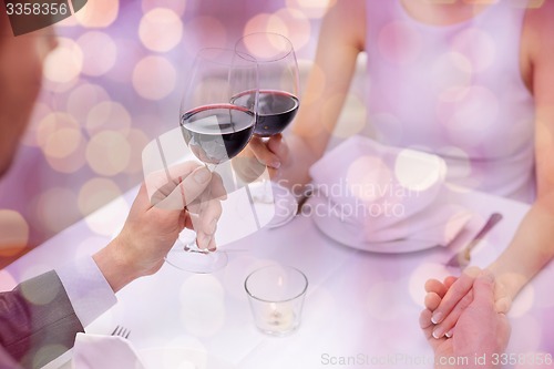 Image of young couple with glasses of wine at restaurant