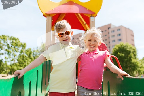 Image of two happy kids hugging on children playground