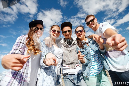 Image of smiling teenagers in sunglasses hanging outside