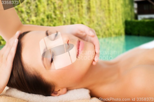 Image of beautiful woman in spa salon having facial massage