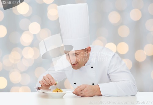 Image of happy male chef cook decorating dish