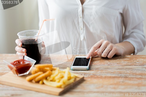 Image of close up of woman with smart phone and fast food