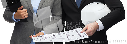 Image of businesspeople with blueprint and helmet