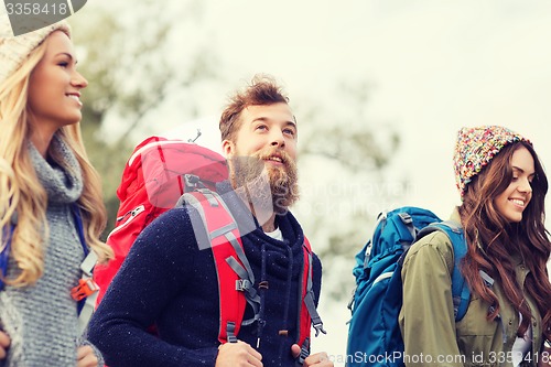 Image of group of smiling friends with backpacks hiking