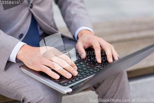 Image of close up of business man with laptop in city