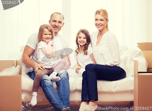 Image of smiling parents and two little girls at new home