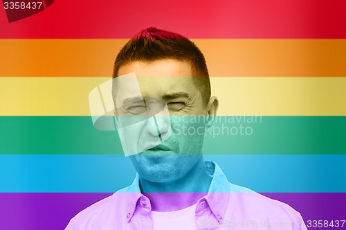 Image of gay man wrying over rainbow flag background