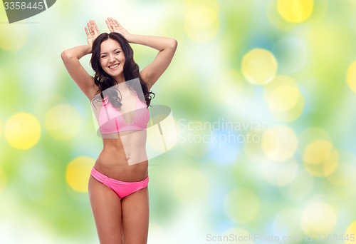 Image of happy young woman in pink bikini swimsuit