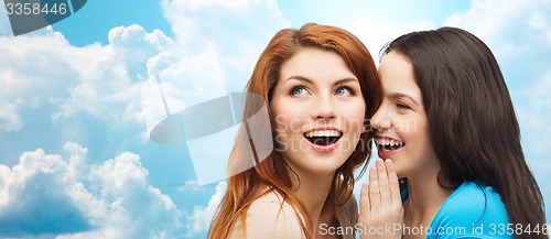 Image of teenage girls or women whispering gossip