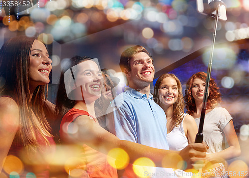 Image of friends with smartphone taking selfie in nightclub