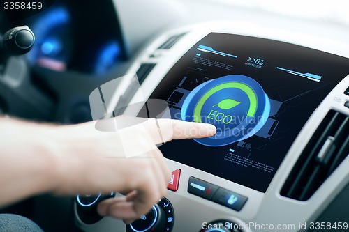 Image of male hand setting car eco system mode on screen