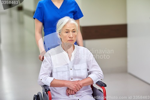 Image of nurse with senior woman in wheelchair at hospital