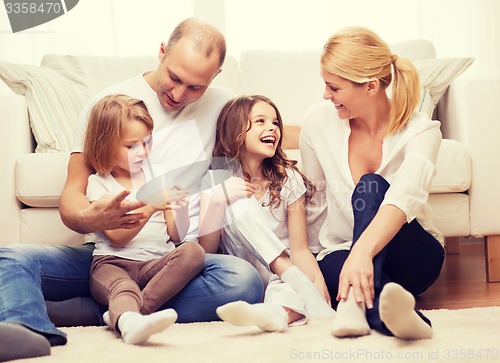 Image of parents and two girls sitting on floor at home
