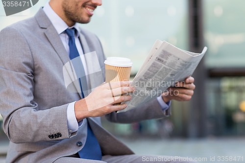 Image of close up of smiling businessman reading newspaper