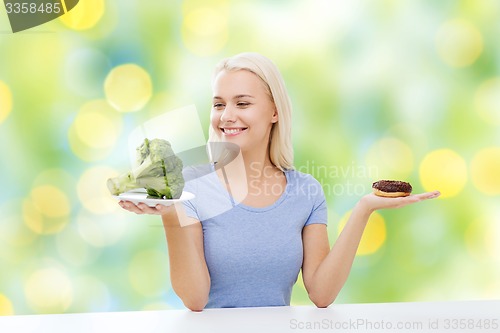 Image of smiling woman with broccoli and donut