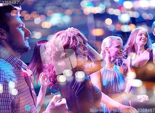 Image of smiling friends dancing in club