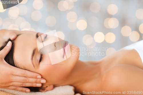 Image of beautiful woman in spa salon having facial massage