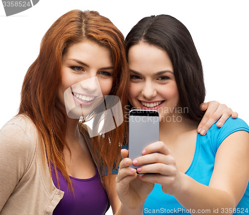 Image of two smiling teenagers with smartphone