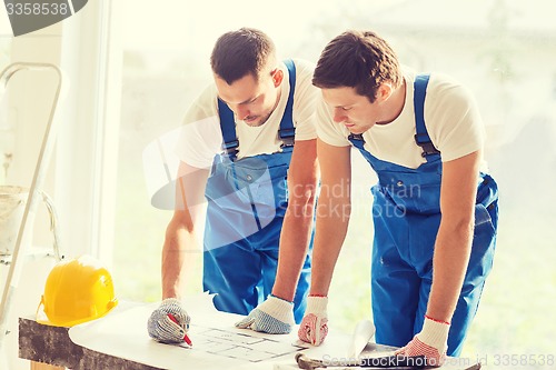 Image of group of builders with blueprint