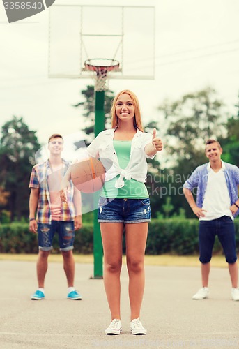 Image of group of smiling teenagers playing basketball